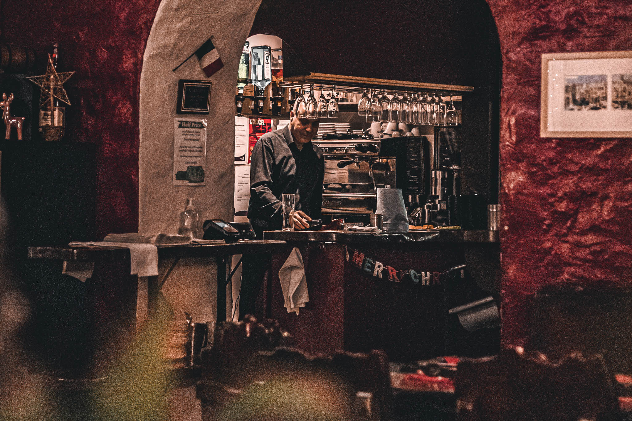 A bar tender standing at Claudio's in-house bar